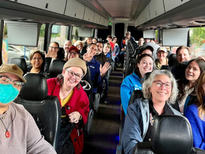The inside of a bus filled with smiling Habitat staff.